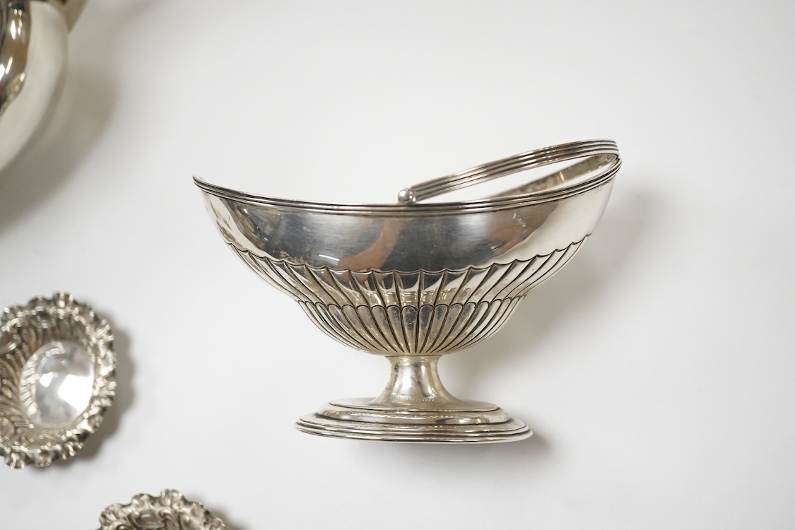 A late Victorian silver boat shaped sugar basket, by Thomas Bradbury & Sons, London, 1896, length 13.2cm, together with a pair of late Victorian repousse silver nut dishes and a silver condiment spoon. 4.8oz.